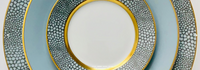 Three stacked Makassar Gold Dinnerware plates by Royal Limoges, handmade in France, feature a blue and white pattern with gold filet and textured, scale-like rims.