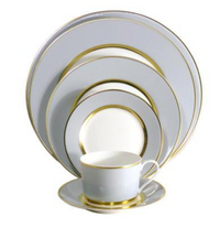 The Royal Limoges Recamier Grey & Gold Dinnerware set features stacked plates, a saucer, and a teacup in white porcelain with elegant gold trim, beautifully crafted in France.