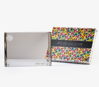 An Apeloig Collection box with a colorful geometric pattern sits beside a clear acrylic "Shabbat Shalom" frame, perfectly complementing your Apeloig Personalized Solid Acrylic Challah Board.