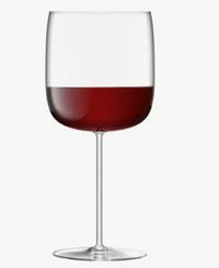 A Borough Barware Set of 4 grand cru glass by LSA, filled halfway with red wine, is showcased against a plain white background.