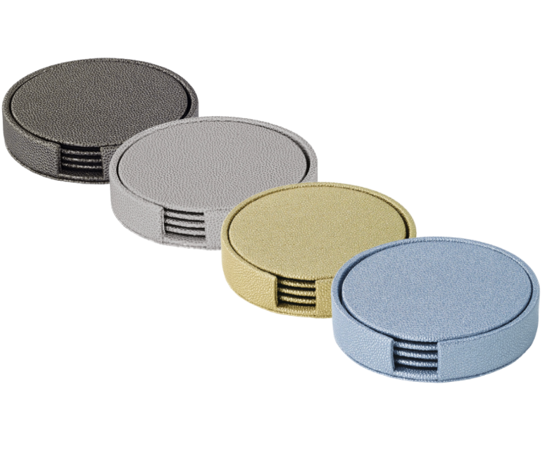 The Bodrum Skate Coaster Set of 4 features round, textured, phthalate-free vinyl coasters in black, silver, gold, and blue. Each has a side groove and is stylishly arranged in a diagonal line.