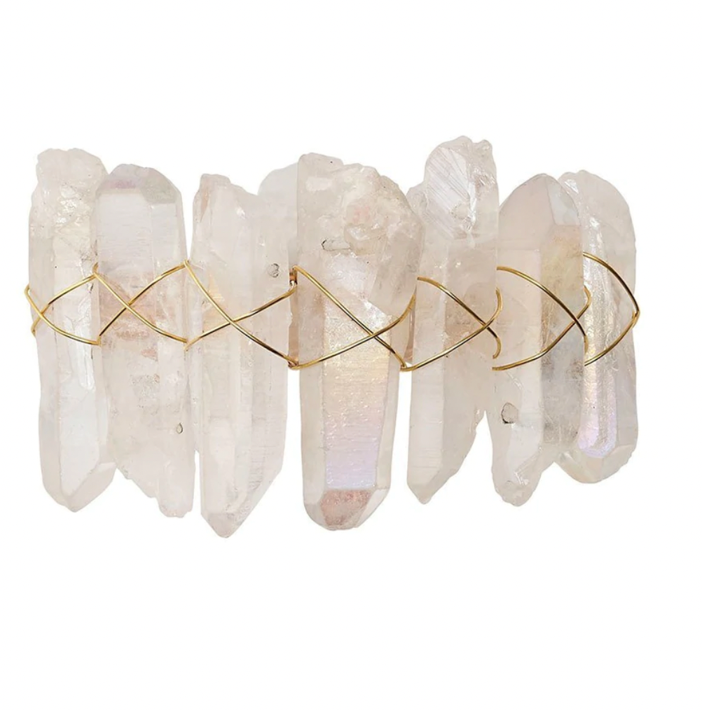 The Kim Seybert Radiant Napkin Ring Iridescent Set of 4 features clear crystal points arranged side by side and wrapped in thin gold wire in a crisscross pattern, reminiscent of rock crystal, against a plain white background.