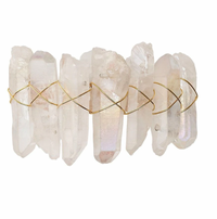 The Kim Seybert Radiant Napkin Ring Iridescent Set of 4 features clear crystal points arranged side by side and wrapped in thin gold wire in a crisscross pattern, reminiscent of rock crystal, against a plain white background.
