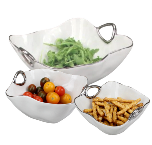 Three PAMPA BAY Handle Bowl Silver Trim pieces—white porcelain with silver handles, dishwasher safe—display leafy greens, cherry tomatoes, and pretzel sticks. Their overlapping arrangement adds modern elegance to your serveware.