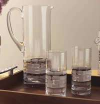 The Michael Wainwright Truro Platinum Pitcher and two matching glasses with a frosted brick pattern rest on a wooden tray against a neutral backdrop.