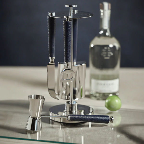 The Zodax Laguna Tool Bar Set, featuring metal and dark handles, stands on a counter with a jigger, clear liquor bottle, and lime in the background.
