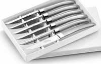 The Capdeco Le Thiers Steak Knives Matte Silver Set of 6 features stainless steel knives with curved handles, inspired by classic French cutlery, presented in a sleek white box with a partially open lid.