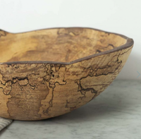 The Peterman Spalted Maple Oval Wood Bowl 18", featuring a handcrafted, irregular edge and unique dark grain patterns, is displayed on a light marble surface.