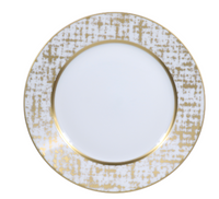 The Tweed White & Gold Dinnerware by Royal Limoges features a round white plate with a wide, textured gold and white rim in an abstract grid pattern, a solid gold inner band, and a plain white center—an elegant handcrafted piece.