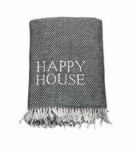 The Happy House Throw by A Soft Idea is a black and white woven blanket with white fringe and "HAPPY HOUSE" embroidered on the front. This home exclusive is machine washable for easy care.