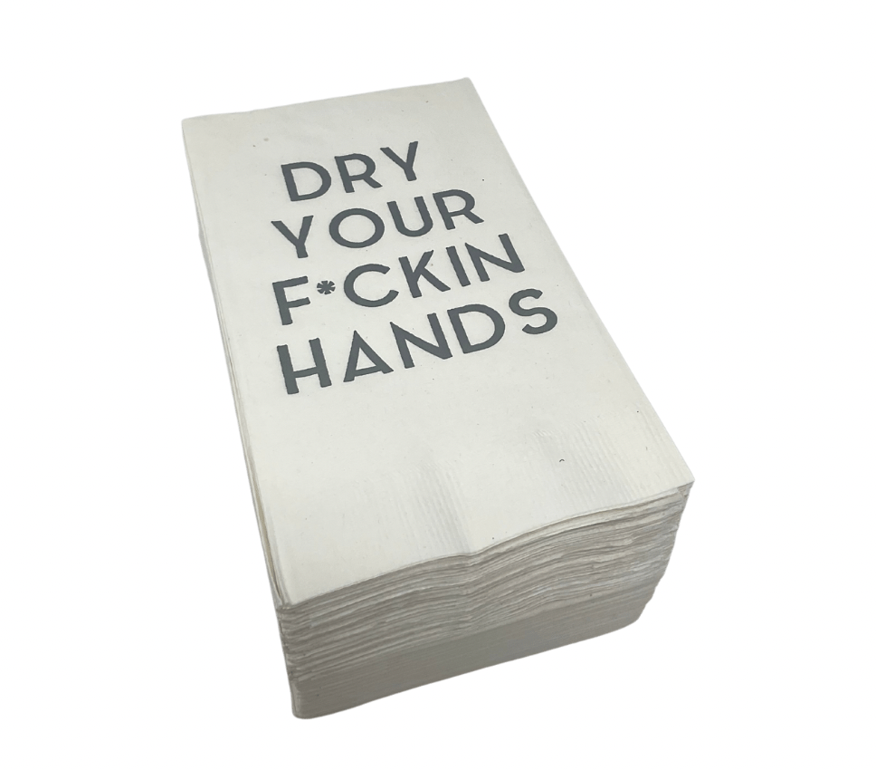The Print Appeal Guest Hand Towel Pack features white disposable napkins with "DRY YOUR F*CKIN HANDS" in bold black print, perfect for guest bathrooms or pairing with an acrylic napkin holder.