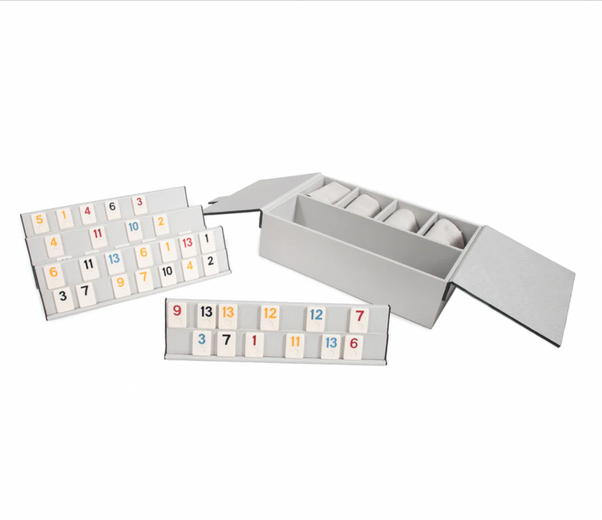 The Brouk & Co Excelsior Rummikub Set Silver features colorful numbered tiles on two black racks, plus extra walnut tiles, all stored neatly inside a stylish leather box.
