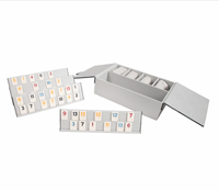 The Brouk & Co Excelsior Rummikub Set Silver features colorful numbered tiles on two black racks, plus extra walnut tiles, all stored neatly inside a stylish leather box.