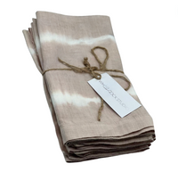 A set of four hand dyed linen napkins in dusty rose by Whigstock Studio, folded and tied with brown twine, includes a white tag—ideal for those who value sustainable essentials.