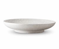 The Alchimie Dinnerware White by L'Objet is a wide, shallow ceramic bowl with a subtle speckled pattern in off-white earthenware, shown on a white background.