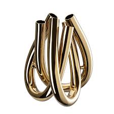 The Trui Vase by Rosenthal features four intertwining, upright gold tubes in a modern sculptural design, enhanced with a durable PVD coating for lasting brilliance.