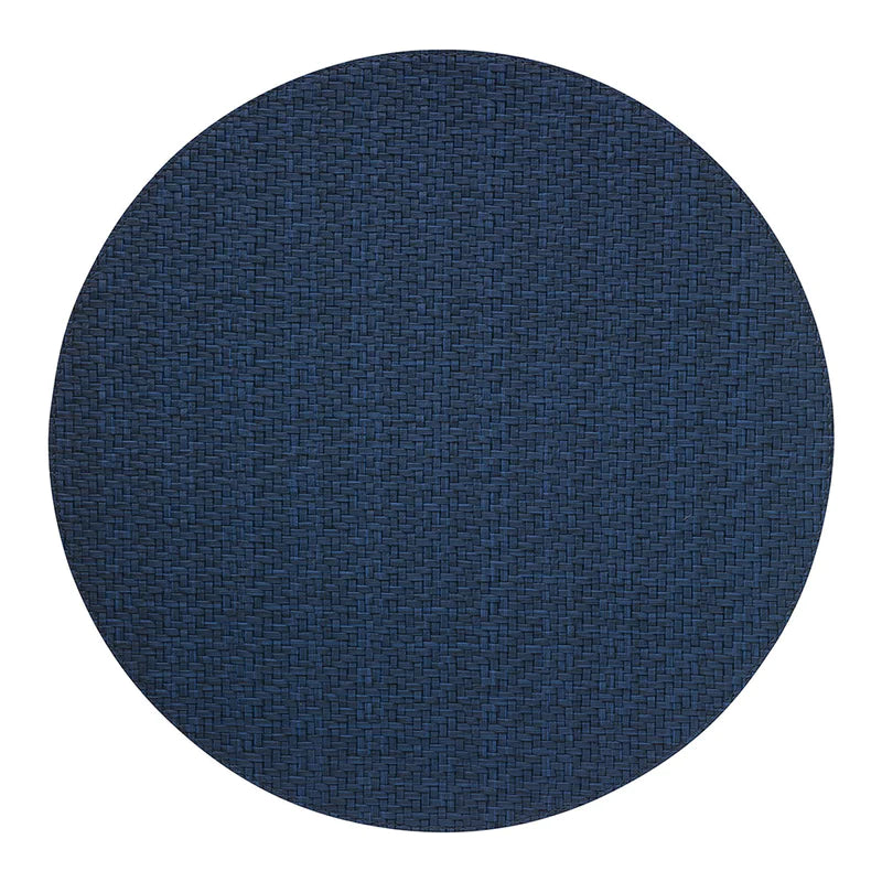 The Bodrum Wicker Round Placemat Navy Set of 4 features dark blue, easy-care woven vinyl placemats in a circular design, shown on a plain white background.