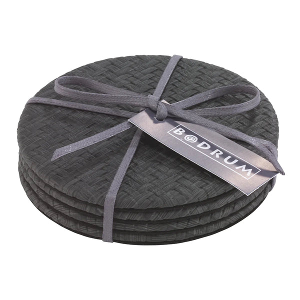 The Bodrum Wicker Easy Care Coaster Set includes four round black wicker coasters tied with a gray ribbon, featuring a tag with the Bodrum brand name.