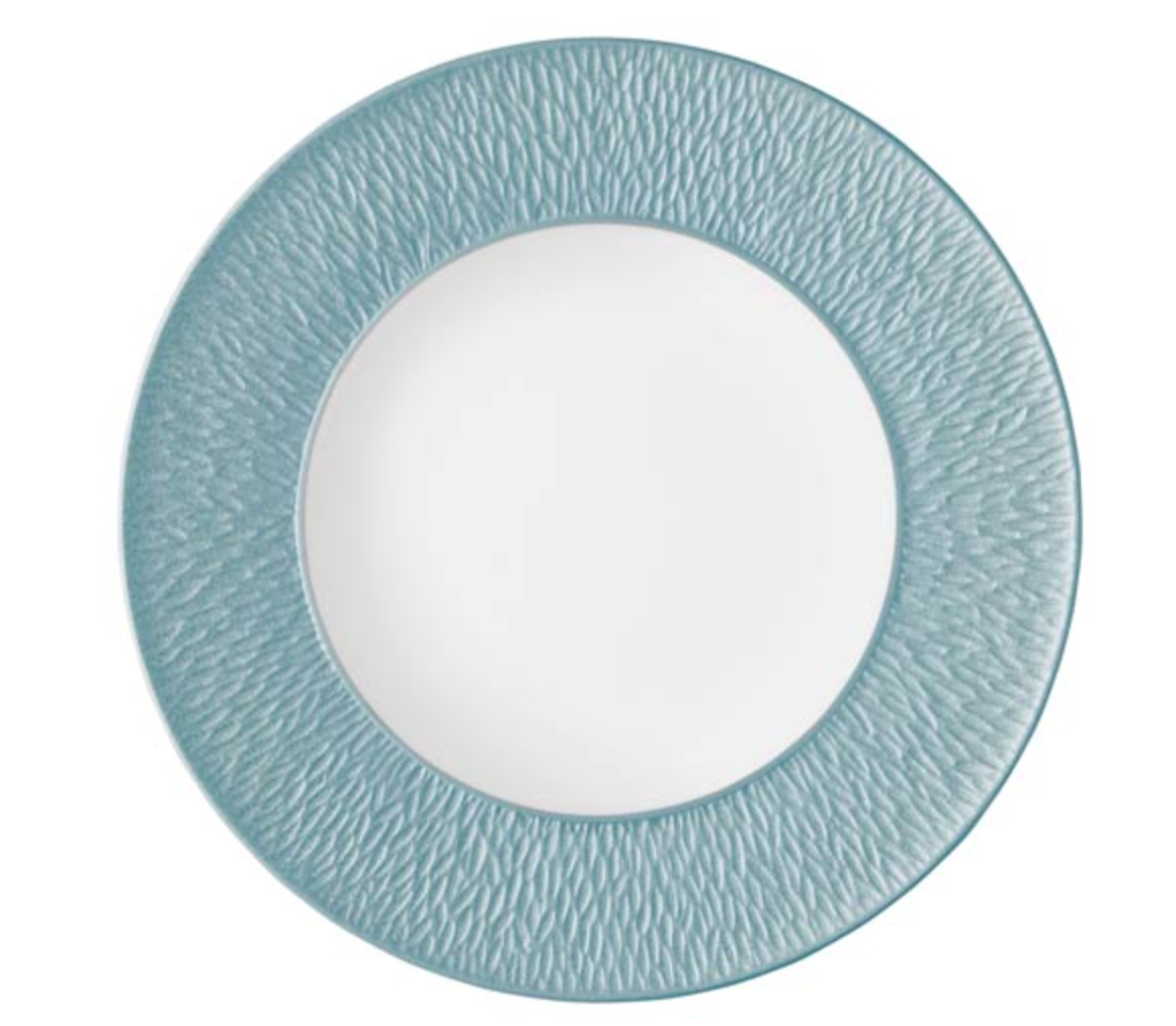 The Mineral Irise Dinnerware Sky Blue by Raynaud features a round white Limoges porcelain plate with a wide, textured sky blue rim and smooth center, showcasing elegant modern style with its subtle, wavy border pattern.