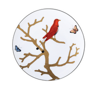 The Aux Oiseaux Dinnerware by Bernardaud showcases a Limoges porcelain plate with a red bird on a brown branch, accompanied by blue and pink butterflies, set against a crisp white background.