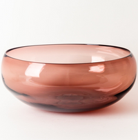 The Gary Bodker Nesting Bowls Rose is a hand blown glass bowl with smooth edges and a translucent dusty rose color, shown against a plain white background.