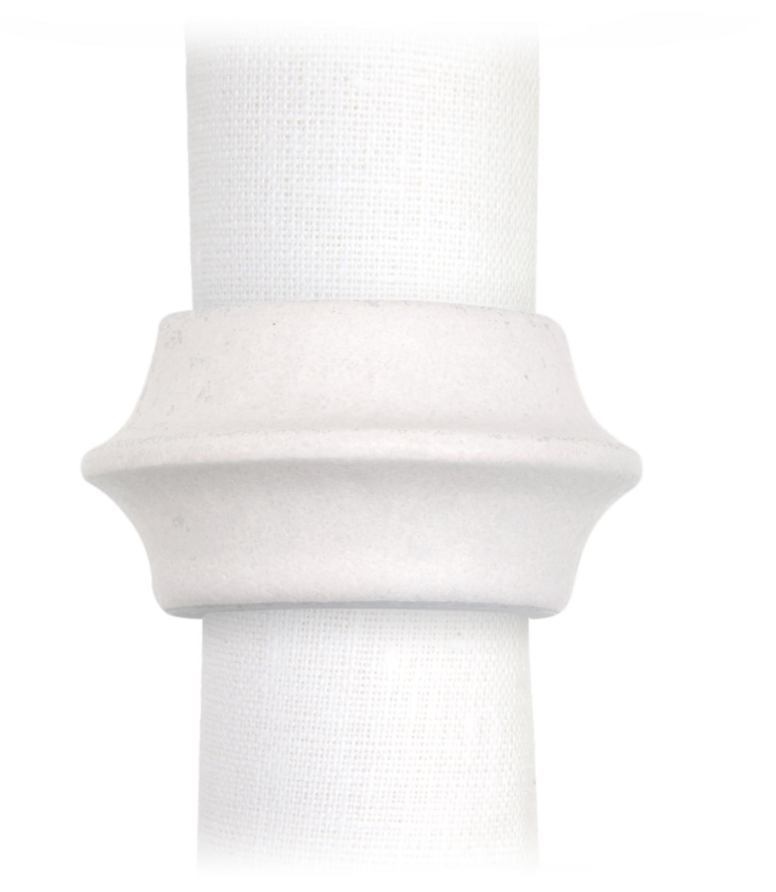 A white cloth napkin is held by L'Objet's Terra Cuff Napkin Ring, a hand-crafted, flared porcelain ring with ridged detailing. Set of 4 shown against a plain white background.