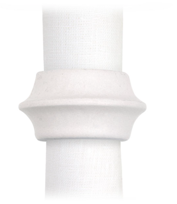 A white cloth napkin is held by L'Objet's Terra Cuff Napkin Ring, a hand-crafted, flared porcelain ring with ridged detailing. Set of 4 shown against a plain white background.