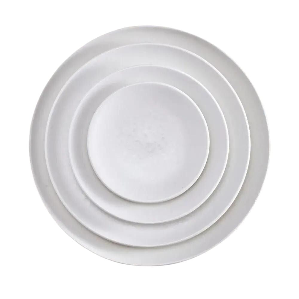 Four white, round Alchimie Dinnerware plates by L'Objet are stacked neatly inside one another, viewed from above on a plain white background—luxurious tableware ideal for any refined setting.