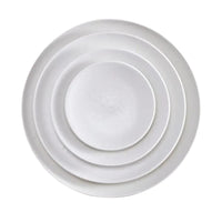 Four white, round Alchimie Dinnerware plates by L'Objet are stacked neatly inside one another, viewed from above on a plain white background—luxurious tableware ideal for any refined setting.