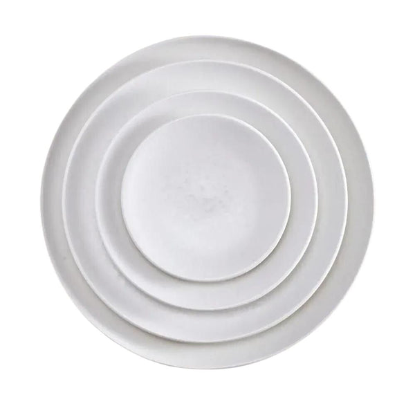 Four white, round Alchimie Dinnerware plates by L'Objet are stacked neatly inside one another, viewed from above on a plain white background—luxurious tableware ideal for any refined setting.