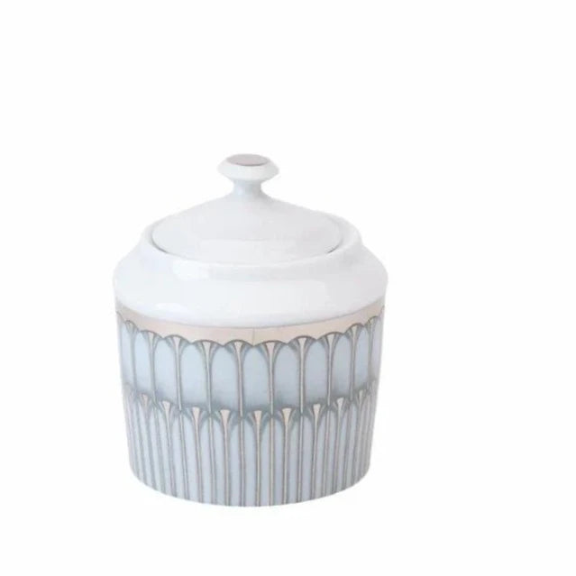 The Arcades Platinum Dinnerware by Philippe Deshoulieres BIA is a white ceramic jar with a lid, featuring a silver and gray geometric pattern, a small handle on top, and a smooth, glossy finish inspired by Limoges porcelain.