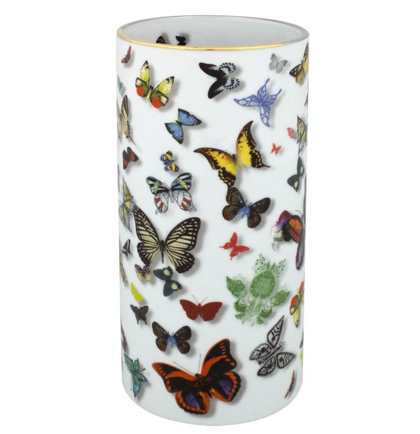The Butterfly Parade Vase by Christian Lacroix for Vista Alegre is a tall, cylindrical white porcelain vase adorned with an array of vibrant butterfly motifs that dance across its surface.