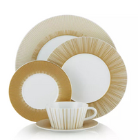 The Sol Dinnerware set by Bernardaud features Limoges porcelain pieces with gold radial lines—a dinner plate, salad plate, bread plate, cup, and saucer—beautifully arranged against a white background.