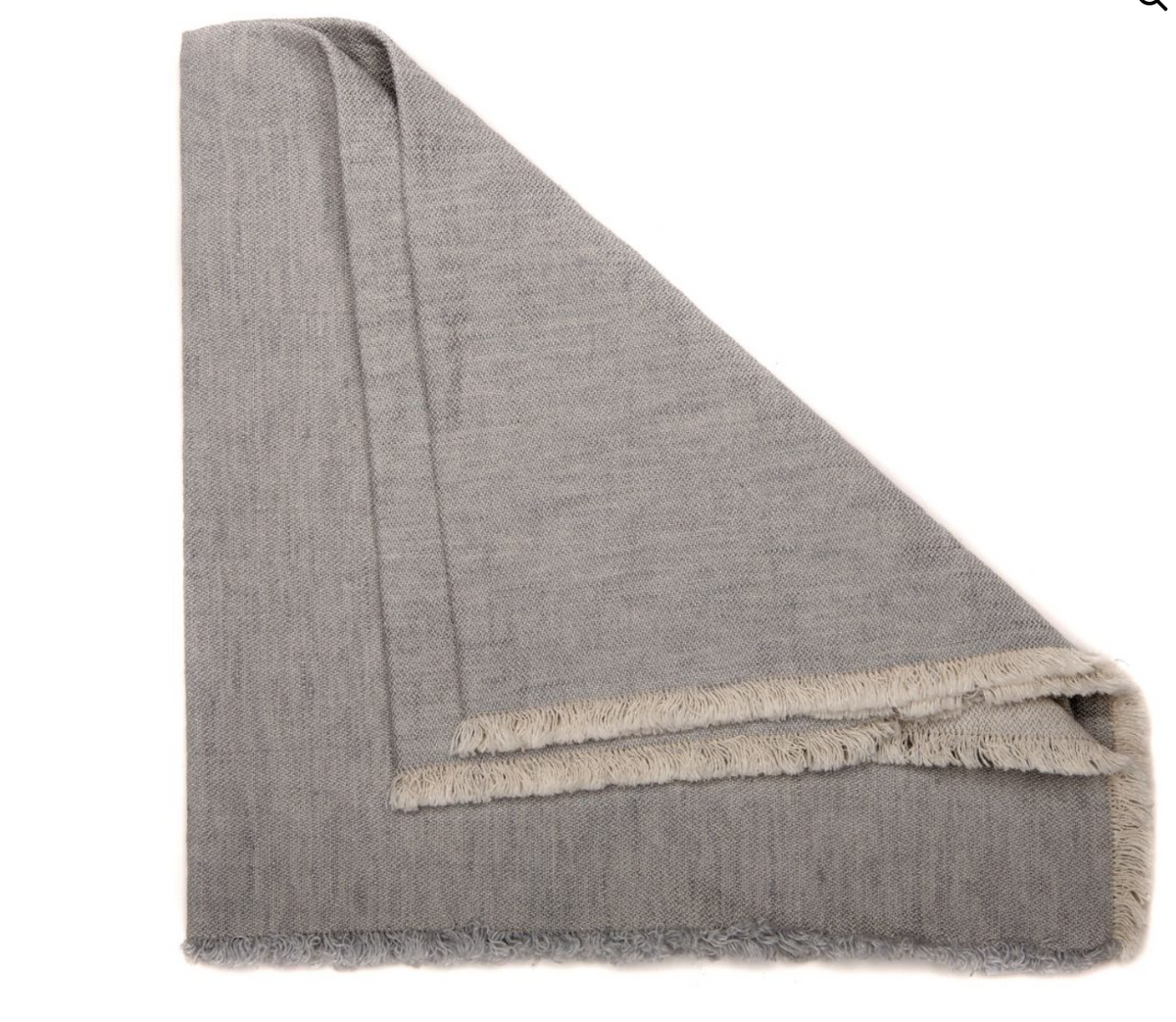 A set of four Deborah Rhodes Woven Washed Fringe Napkins in light gray, featuring soft, folded fabric and fringed edges, displayed on a white background.