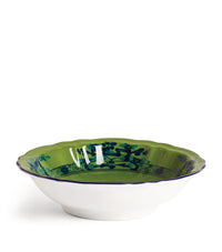 The Oriente Italiano Dinnerware Malachite by Ginori 1735 is a shallow white ceramic bowl with a scalloped edge, glossy green interior, and blue rim pattern, elegantly displayed against a plain white background.