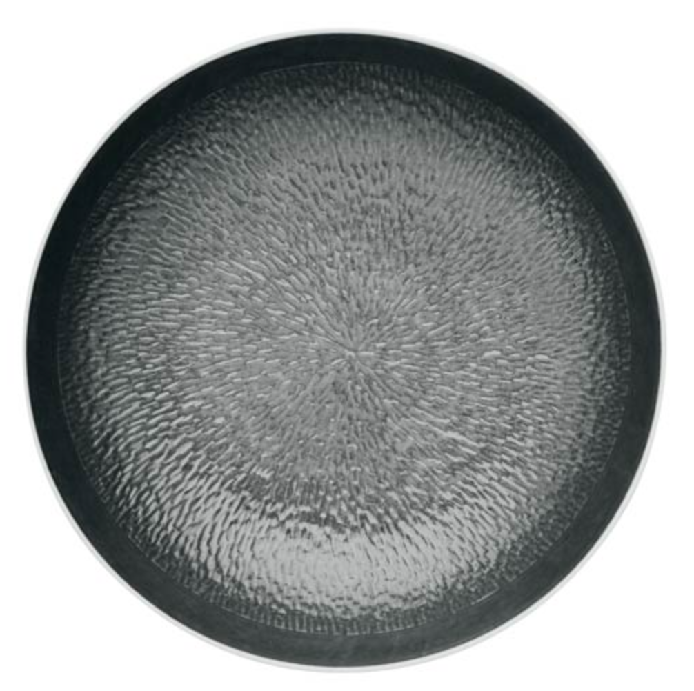 The Raynaud Mineral Irise Dinnerware in Black features a round, textured dimpled plate with a subtle hammered-metal look and smooth, slightly raised rim, offering a contemporary twist on classic design.