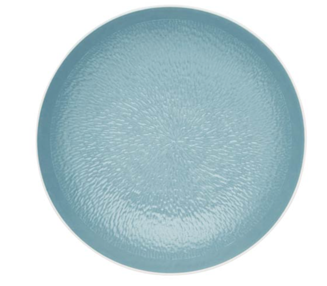 The Mineral Irise Dinnerware Sky Blue plate by Raynaud is a round, light blue ceramic piece with a textured, slightly glossy surface, crafted in modern style and shown from above on a white background.
