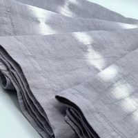 A close-up of Whigstock Studio’s Hand Dyed Linen Napkin Set of 4 in Lavender Gray, highlighting unique tie-dye texture and fine stitching—ideal for those seeking distinctive, sustainable table linens.