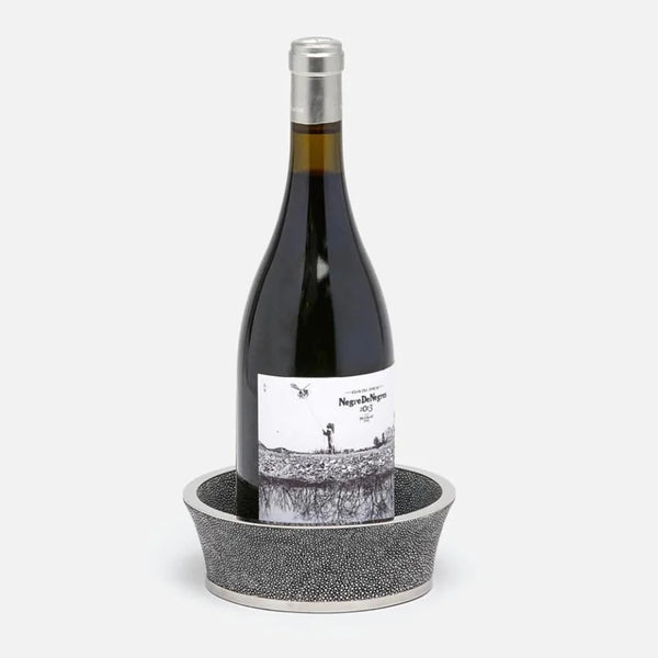 The Angelica Grey Shagreen Wine Coaster by Blue Pheasant features elegant silver detailing and a luxe finish, making it the perfect stylish accent for gifting or entertaining. Set your favorite bottle upright in sophisticated style.