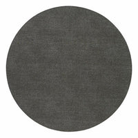 The Bodrum Presto Placemat Round Charcoal Set of 4 features round, dark gray vinyl mats with a stonewashed linen look and smooth texture, photographed from above on a white background. Easy-care and stylish for any space.