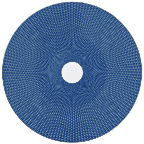 The Raynaud Tresor Dinnerware Blue features a round, flat blue disc with a small white central hole and a textured geometric pattern of raised squares for an elegant, woven look.