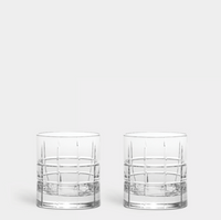 Two Orrefors Kosta Boda Street DOF Glasses from the Set of 2, featuring a grid-like etched pattern, are placed side by side on a plain light gray background.