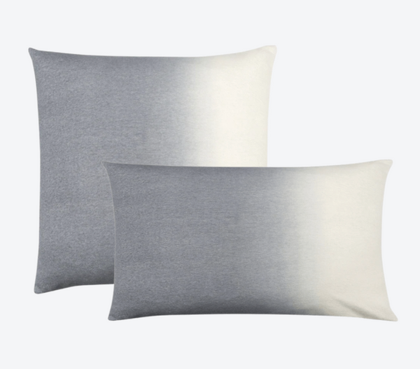 Two Johanna Howard Dip Dye Pillow Light Grey pillows—one square, one rectangular—feature a stylish ombré from gray to white and are displayed overlapping on a light gray background, perfect for anyone seeking a refined dip-dyed accent.