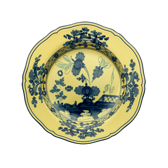 The Oriente Italiano Dinnerware Citrino by Ginori 1735 is a round, yellow ceramic plate with scalloped edges, adorned with a dark blue chinoiserie floral and geometric motif inspired by classic Ginori Oriente designs.