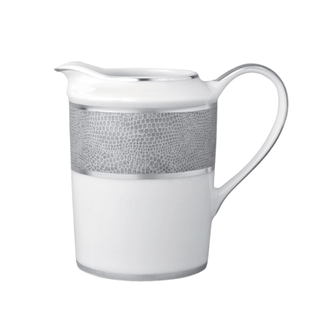 The Bernardaud Sauvage Grey & Platinum pitcher is crafted from white Limoges porcelain with a curved handle, pouring spout, platinum rim, and a textured snake skin-embossed platinum band, giving it a modern, elegant look.