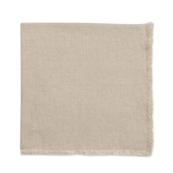 The Deborah Rhodes Herringbone Fringe Napkin Flax Set of 4 features light beige napkins with a subtle herringbone pattern and short fringe, reminiscent of a throw blanket, displayed on a white background.