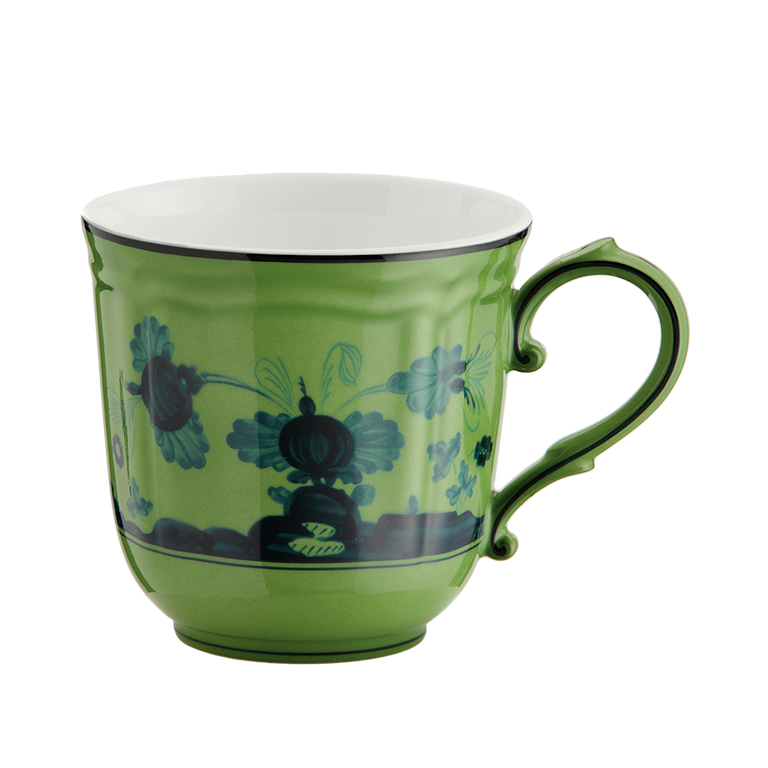 The Ginori 1735 Oriente Italiano Dinnerware Malachite is a green porcelain mug with a decorative black handle, featuring floral and abstract dark blue patterns on white—an exquisite example of Italian craftsmanship.
