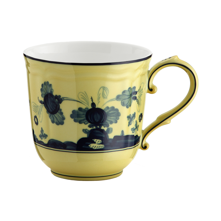 The Oriente Italiano Dinnerware Citrino by Ginori 1735 is a yellow porcelain teacup with a blue chinoiserie floral and vine motif, an elegant curved handle, and a glossy finish inspired by classic Italian porcelain.