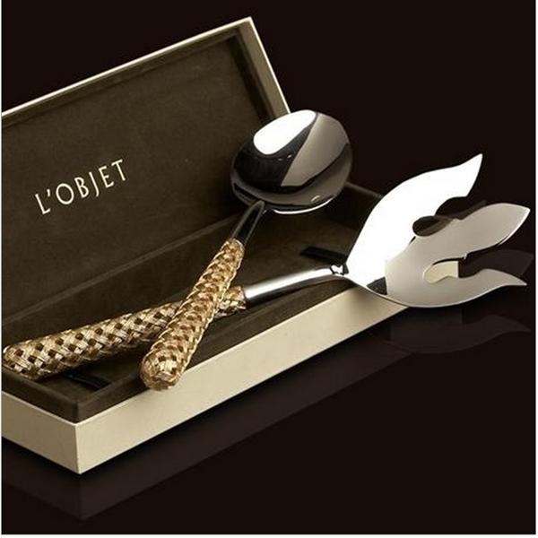 The Braid Serving Set Gold by L'Objet features a ladle and decorative fork with woven 24k gold plated handles, elegantly presented in an open L'Objet gift box against a dark backdrop.
