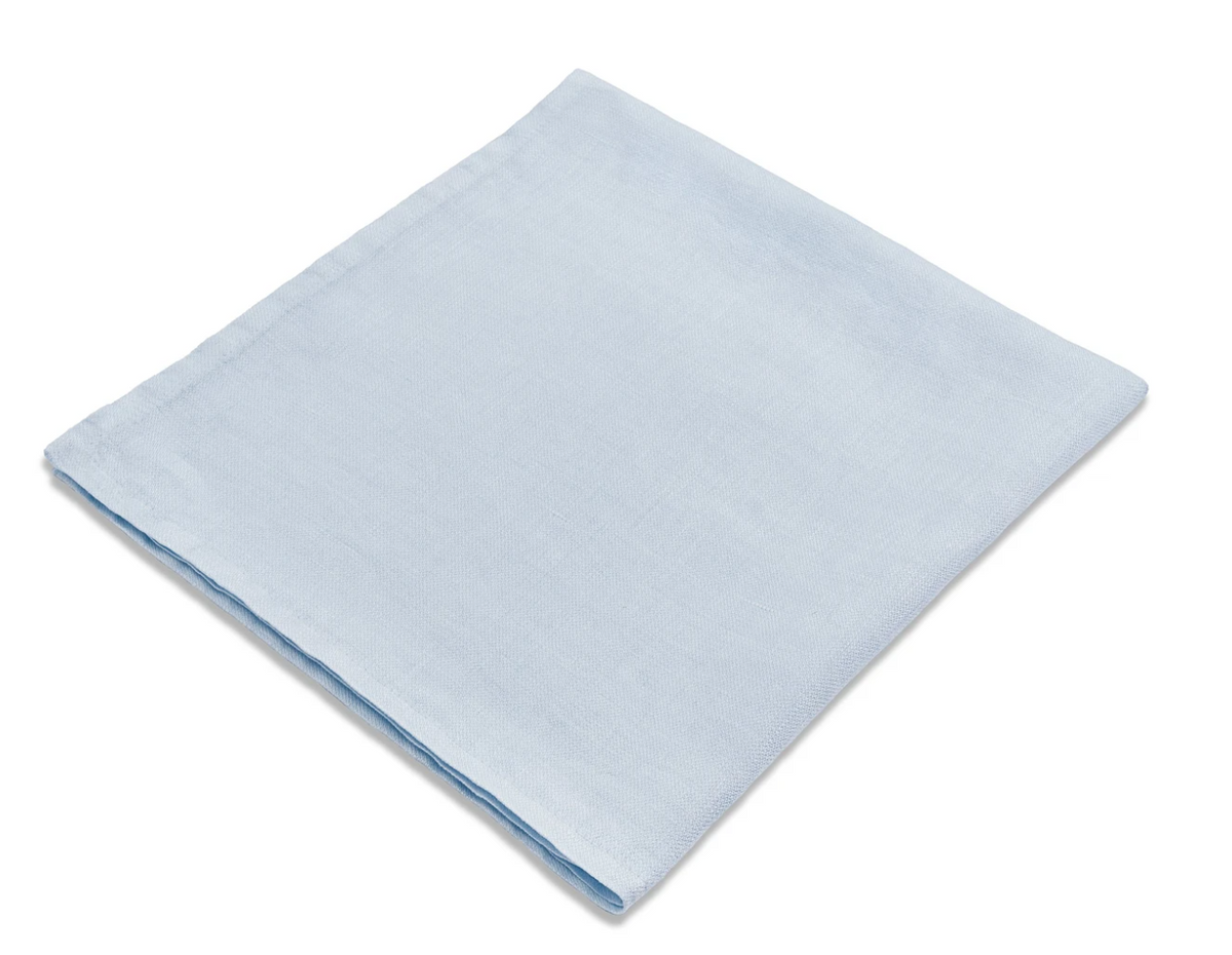 The Linen Sateen Napkin Light Blue Set of 4 by L'Objet, handmade in Portugal from 100% linen, is shown neatly folded on a white background.